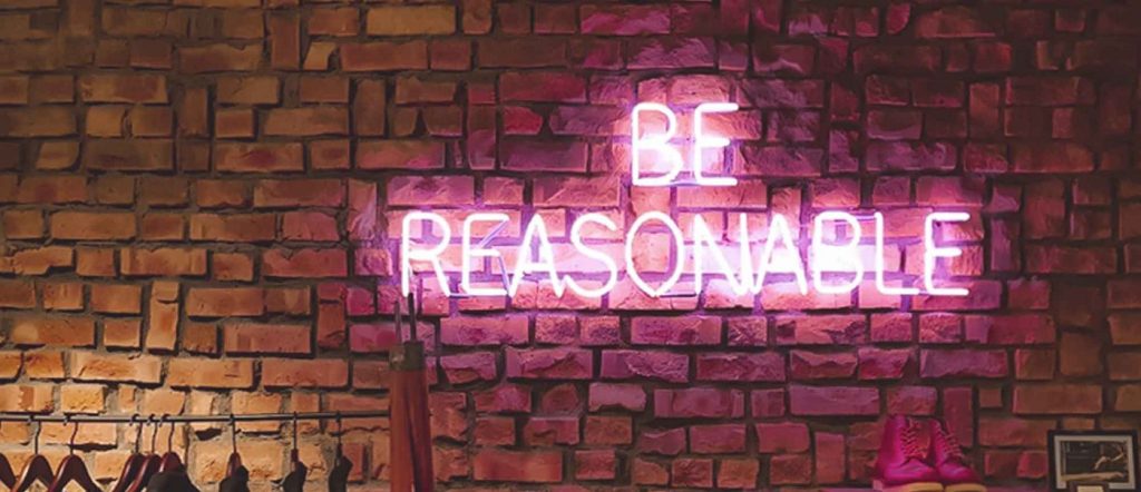 Neon sign "Be reasonable"
