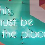 A neon sign "This must be the place""